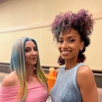 Two models smile for a photo.