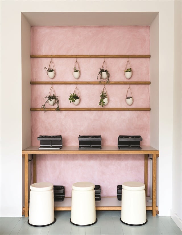 The “millennial” pink walls add softness to the custom-made wooden shelves throughout the space.