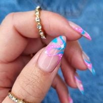 A set of nails with wavy pink and blue art. Barbiecore and mermaid nails are already looking to...