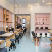 The salon interior hosts an abundance of plants and fresh flowers along the sides of each...