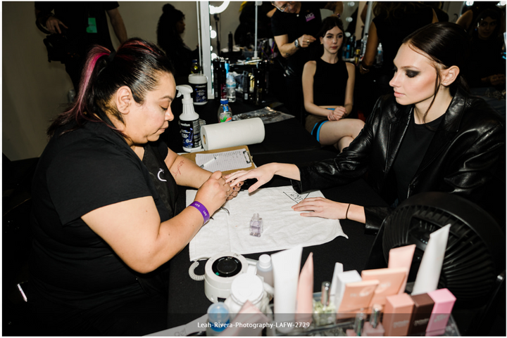 A nail technician uses the 1-minute disinfectant between models at this year's LAFW.